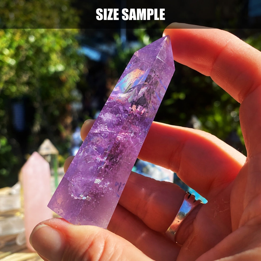 A hand holding an amethyst point to show its size