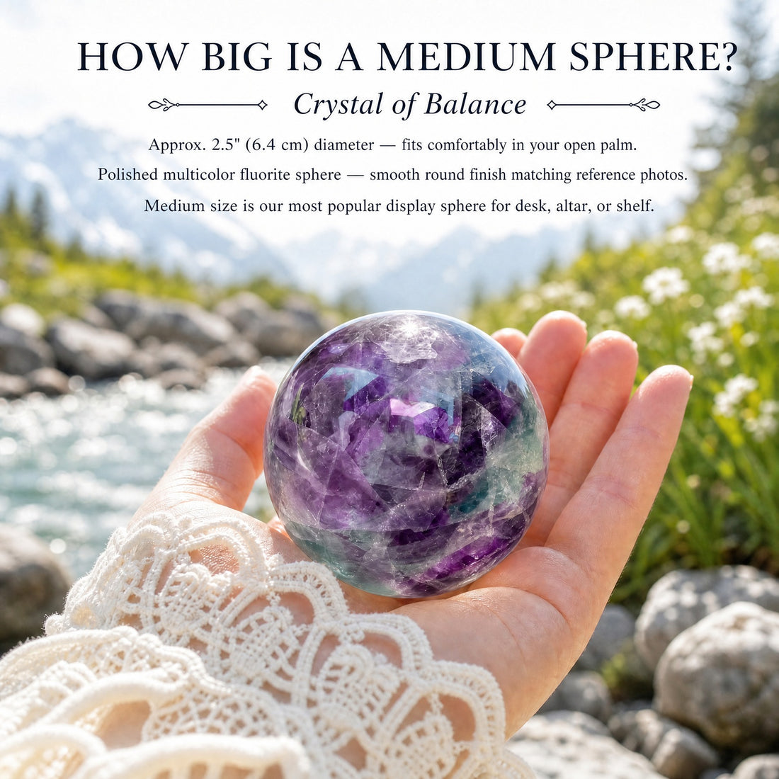A polished purple and green multicolor fluorite sphere resting in an open palm beside a mountain stream