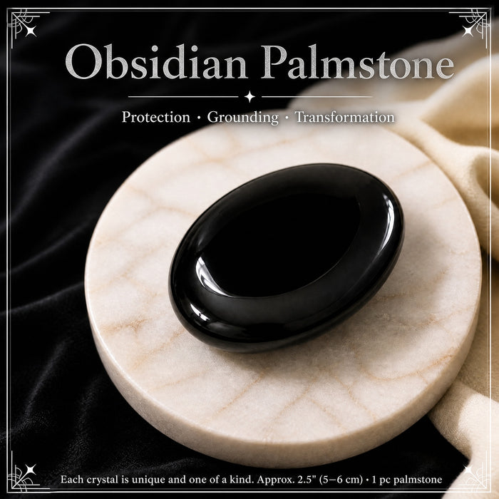 Glossy black obsidian palmstone on a white stone dish
