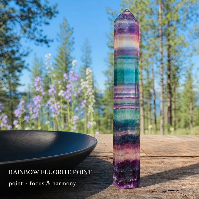 A tall banded rainbow fluorite point among trees and lupines
