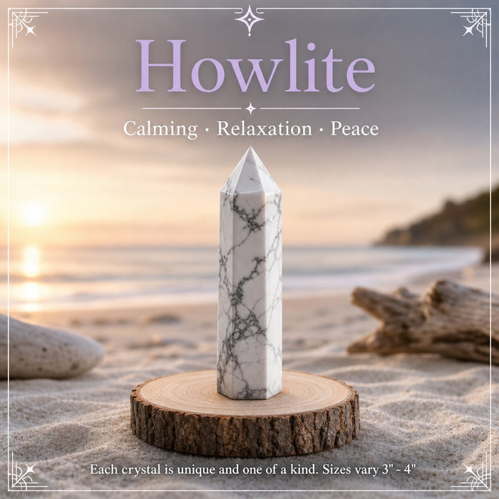 A white howlite point with grey veining on a beach at sunset