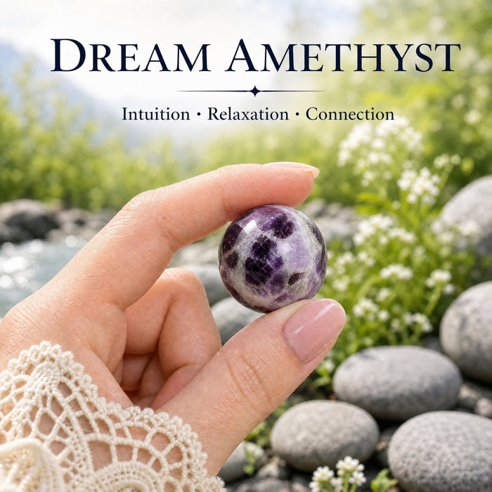 A small dream amethyst sphere with purple patches in milky white, held between finger and thumb
