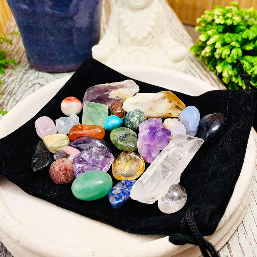 All 26 crystals from the set spread out on the black velvet pouch