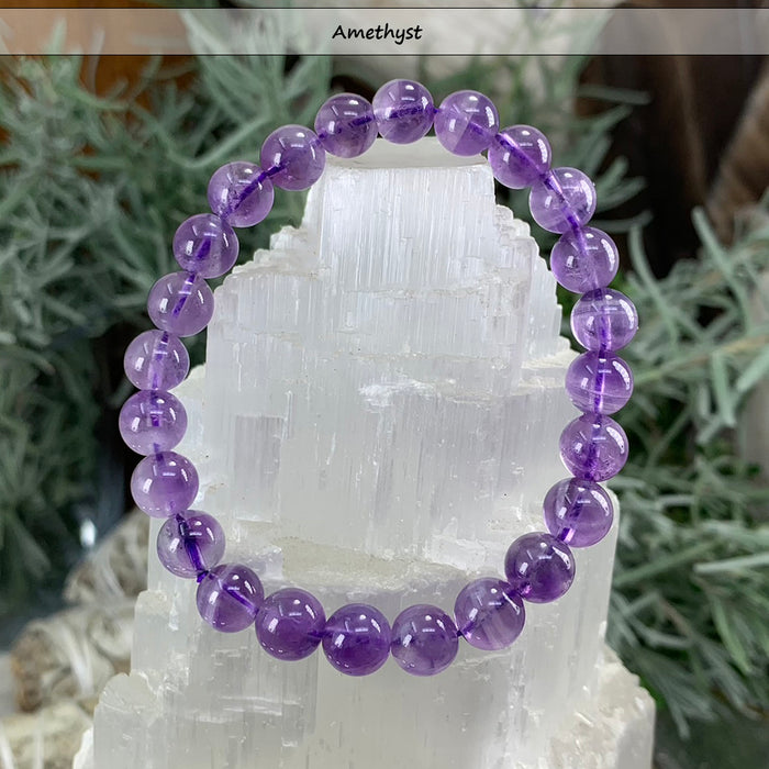 Purple amethyst bead bracelet on a selenite tower