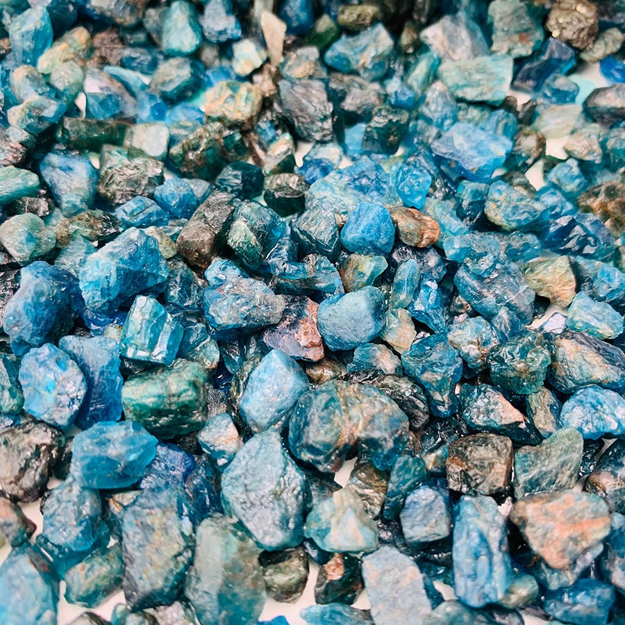 Close-up of rough apatite pieces showing their raw edges and blue to blue-green colour