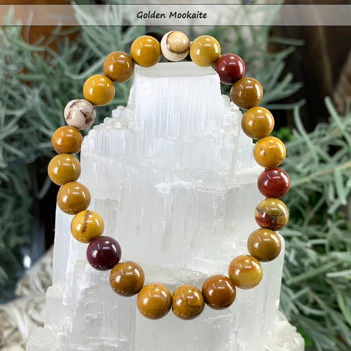 Golden mookaite bead bracelet in mustard, cream and burgundy on a selenite tower