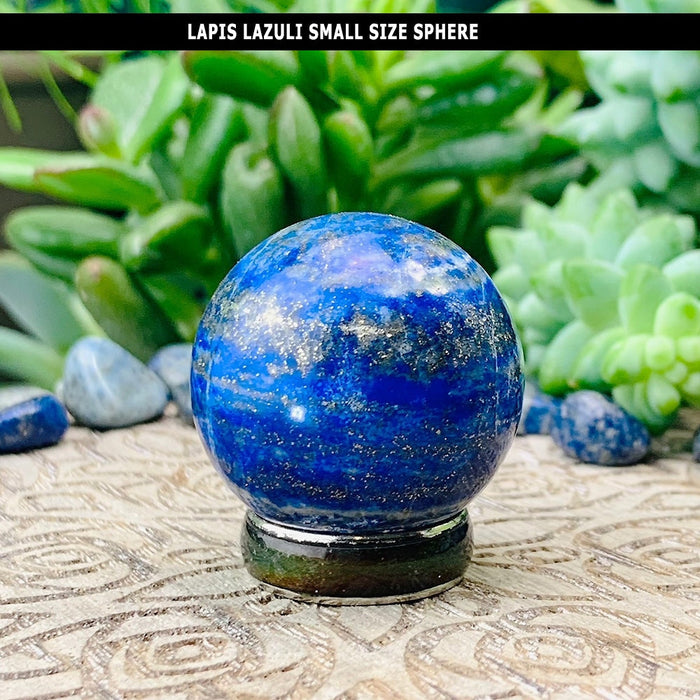 A small deep blue lapis lazuli sphere dusted with golden flecks, resting on a stand