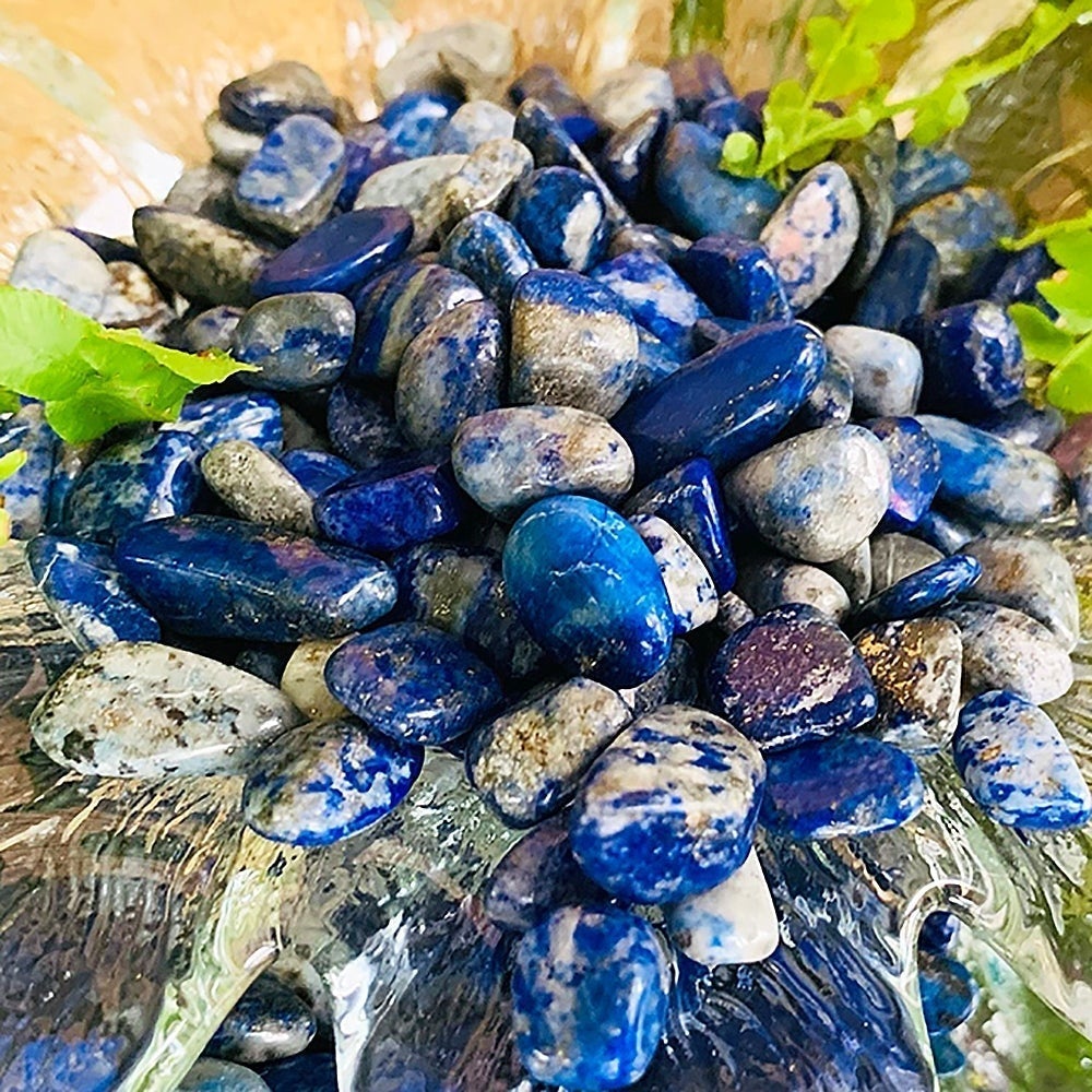 A heap of tumbled lapis lazuli mini gemstones in deep royal blue, denim and grey-white