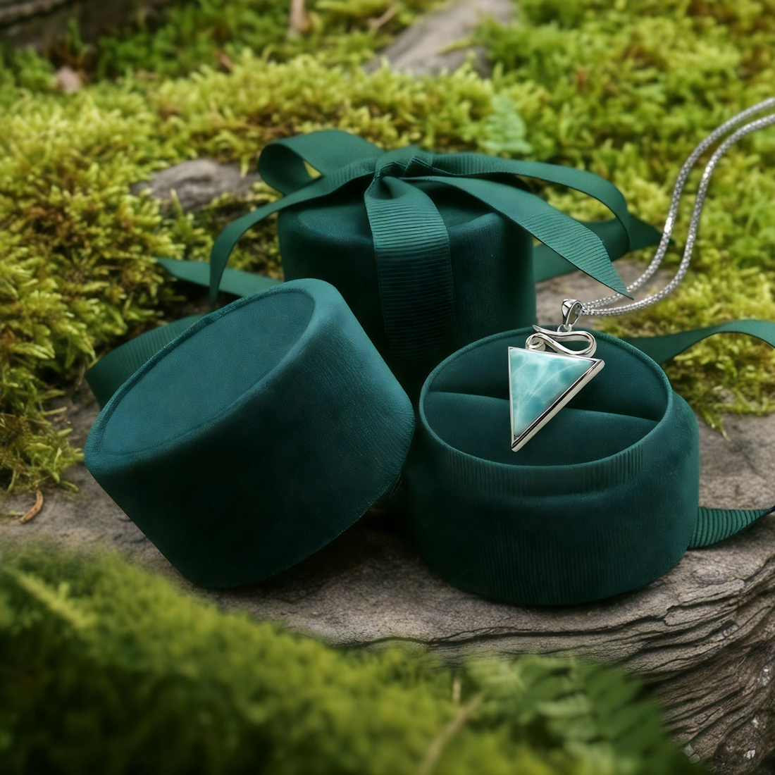 The Larimar pendant resting in an open round green velvet jewelry box