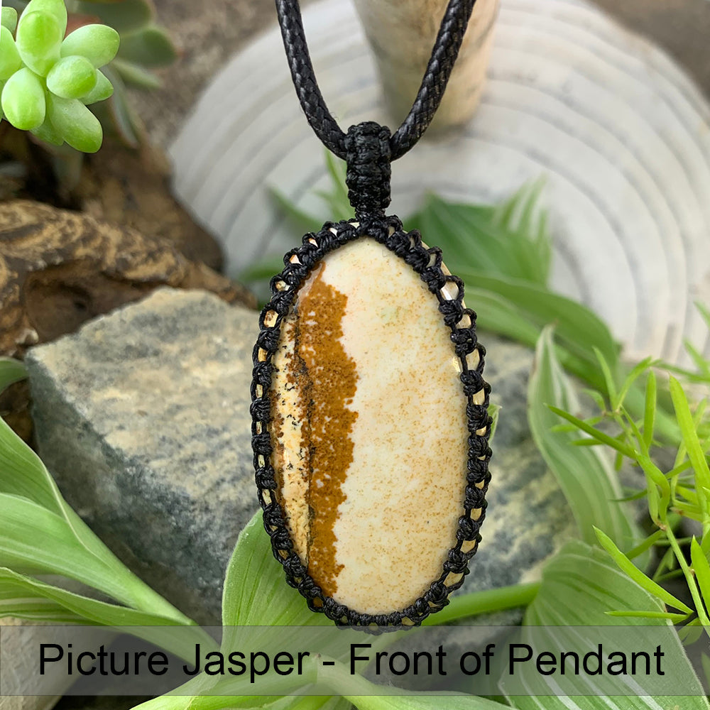 Front of the picture jasper pendant: a cream oval with a rust-brown band, set in black macramé on a black cord