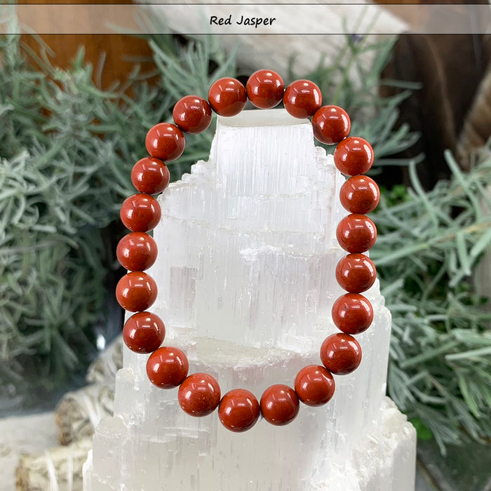 Brick-red red jasper bead bracelet on a selenite tower
