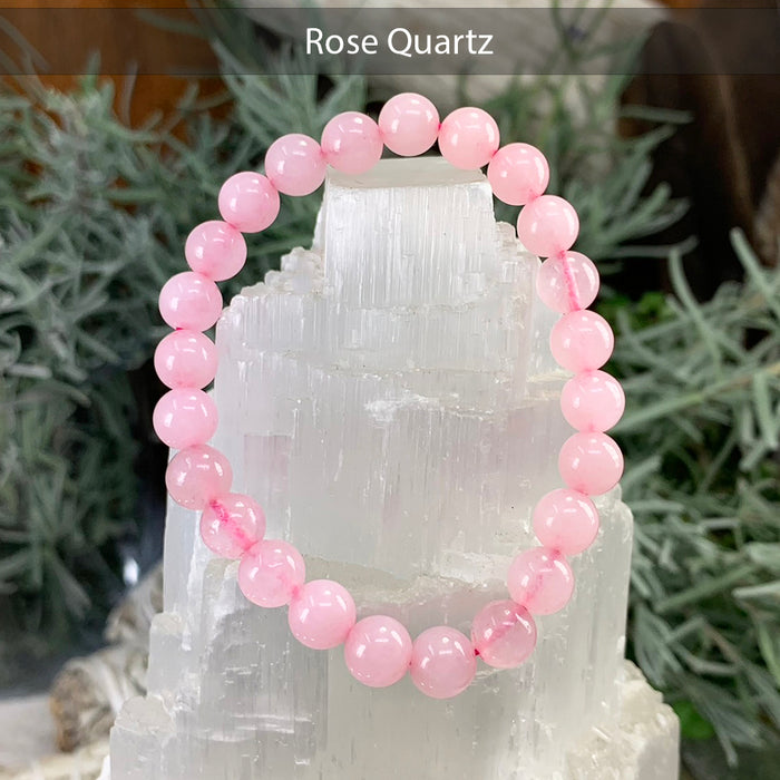 Pink rose quartz bead bracelet on a selenite tower
